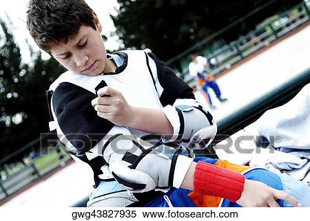 Close-up of a boy getting dressed for ice hockey View Large Photo Image Stock Photography - Close-up of a boy getting dressed for ice hockey. Fotosearch