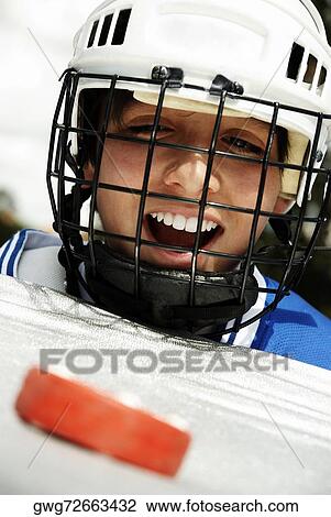Close-up of a boy looking at a hockey puck and laughing View Large Photo Image Stock Image - Close-up of a boy looking at a hockey puck and laughing. Fotosearch