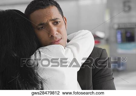 Close-up of a businessman and a businesswoman embracing each other at an airport View Large Photo Image Stock Image - Close-up of a businessman and a businesswoman embracing each other at an airport. Fotosearch