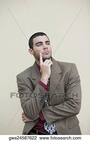 Close-up of a businessman standing with his hand on his chin View Large Photo Image Stock Image - Close-up of a businessman standing with his hand on his chin. Fotosearch