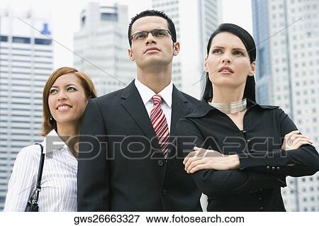 Close-up of a businessman standing with two businesswomen View Large Photo Image Stock Photo - Close-up of a businessman standing with two businesswomen. Fotosearch