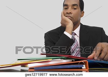 Stock Photo - Close-up of a businessman thinking with his hand on his chin. Fotosearch