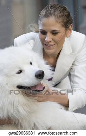Close-up of a businesswoman playing with her dog View Large Photo Image Stock Image - Close-up of a businesswoman playing with her dog. Fotosearch