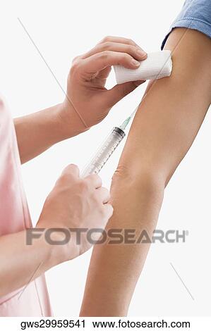 Stock Image - Close-up of a doctor giving injection to a patient. Fotosearch