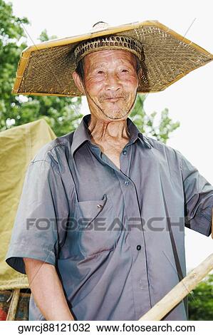 Close-up of a farmer wearing an Asian style conical hat, Zhigou, Shandong Province, China View Large Photo Image Stock Image - Close-up of a farmer wearing an Asian style conical hat, Zhigou, Shandong Province, China. Fotosearch