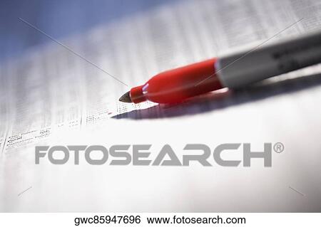 Stock Photograph - Close-up of a felt tip pen on a financial newspaper. Fotosearch