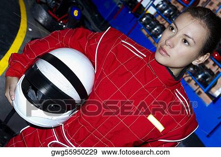 Close-up of a female go-cart racer holding a crash helmet under her arm View Large Photo Image Stock Photo - Close-up of a female go-cart racer holding a crash helmet under her arm. Fotosearch