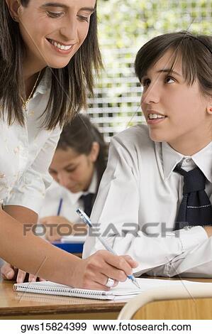 Stock Photo - Close-up of a female teacher with her student in a classroom. Fotosearch