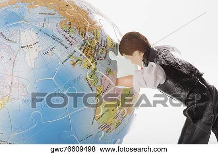 Close-up of a figurine with its hand inside of a globe View Large Photo Image Stock Photo - Close-up of a figurine with its hand inside of a globe. Fotosearch