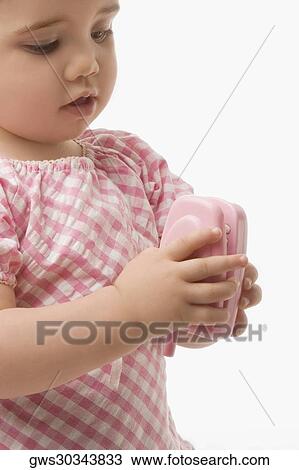 Close-up of a girl playing with a toy phone View Large Photo Image Stock Image - Close-up of a girl playing with a toy phone. Fotosearch
