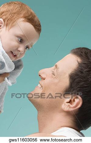 Close-up of a mid adult man playing with his son View Large Photo Image Stock Photograph - Close-up of a mid adult man playing with his son. Fotosearch