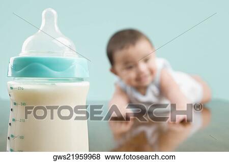 Close-up of a milk bottle with a baby boy in the background View Large Photo Image Stock Photo - Close-up of a milk bottle with a baby boy in the background. Fotosearch