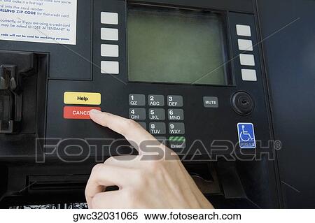 Stock Photography - Close-up of a person's finger using a gas station machine. Fotosearch