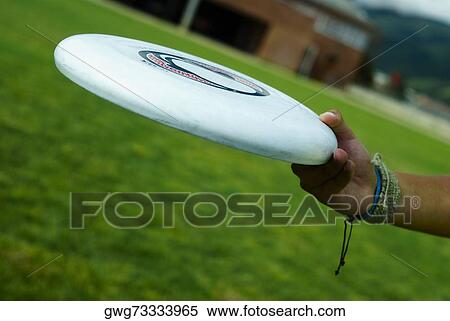 Close-up of a person's hand holding a plastic disc View Large Photo Image Stock Photography - Close-up of a person's hand holding a plastic disc. Fotosearch