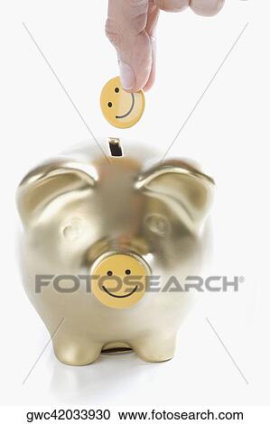 Close-up of a person's hand putting a smiley face into a piggy bank View Large Photo Image Stock Image - Close-up of a person's hand putting a smiley face into a piggy bank. Fotosearch
