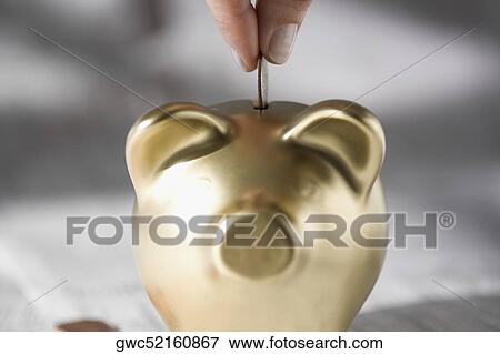 Close-up of a person's hand putting a coin into a piggy bank View Large Photo Image Stock Photo - Close-up of a person's hand putting a coin into a piggy bank. Fotosearch