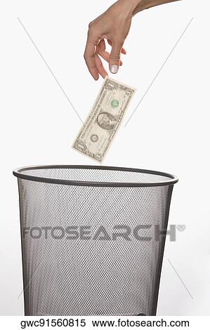 Close-up of a person's hand throwing a US dollar bill in a garbage bin View Large Photo Image Stock Photography - Close-up of a person's hand throwing a US dollar bill in a garbage bin. Fotosearch