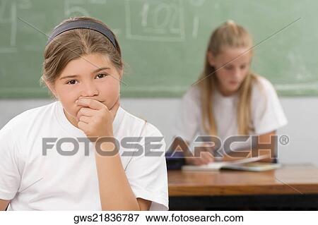 Close-up of a schoolgirl thinking in a classroom View Large Photo Image Stock Photo - Close-up of a schoolgirl thinking in a classroom. Fotosearch