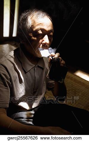 Close-up of a senior man smoking a cigar, Jinkeng Terraced Field, Guangxi Province, China View Large Photo Image Stock Photograph - Close-up of a senior man smoking a cigar, Jinkeng Terraced Field, Guangxi Province, China. Fotosearch