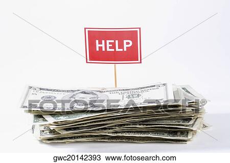 Stock Image - Close-up of a stack of us paper currency with a help signboard. Fotosearch