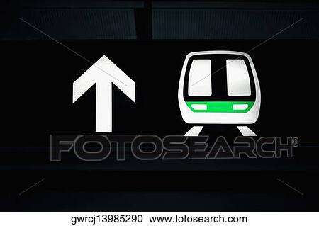 Stock Image - Close-up of a subway train and an arrow sign, Guangzhou, Guangdong Province, China. Fotosearch