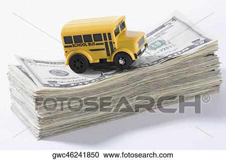Close-up of a toy school bus on a stack of US dollar bills View Large Photo Image Stock Image - Close-up of a toy school bus on a stack of US dollar bills. Fotosearch