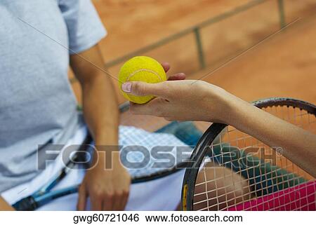 Close-up of a woman's hand giving a tennis ball to a female tennis player View Large Photo Image Stock Photograph - Close-up of a woman's hand giving a tennis ball to a female tennis player. Fotosearch