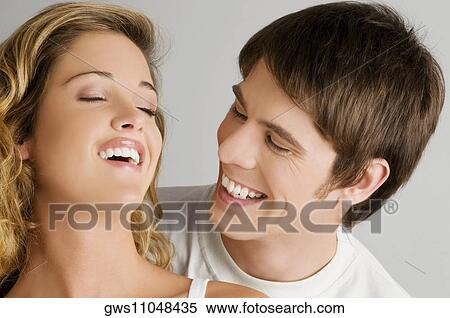 Close-up of a young couple smiling View Large Photo Image Stock Photography - Close-up of a young couple smiling. Fotosearch