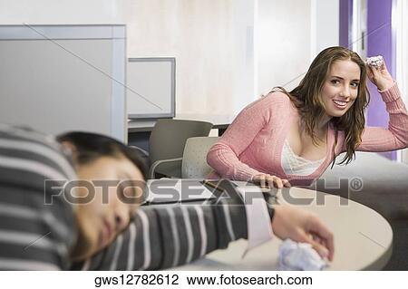 Close-up of a young man napping and a young woman throwing a crumpled paper on him View Large Photo Image Stock Image - Close-up of a young man napping and a young woman throwing a crumpled paper on him. Fotosearch