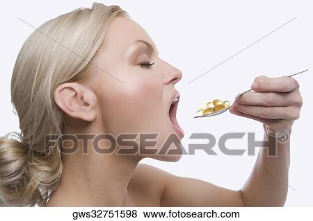 Close-up of a young woman taking a spoon full of pills View Large Photo Image Stock Photo - Close-up of a young woman taking a spoon full of pills. Fotosearch
