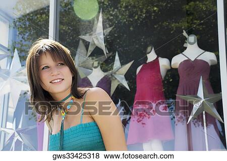 Close-up of a young woman window shopping and smiling View Large Photo Image Stock Photo - Close-up of a young woman window shopping and smiling. Fotosearch