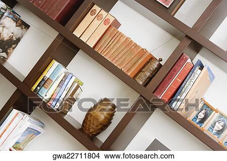 Picture - Close-up of books and picture frames in shelves. Fotosearch