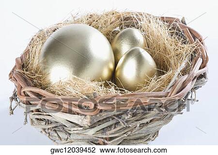 Stock Image - Close-up of golden eggs in a bird's nest. Fotosearch