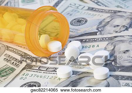Stock Photography - Close-up of medicines and a pill bottle on US paper currency. Fotosearch