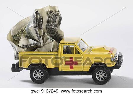 Stock Photo - Close-up of toy pick-up truck carrying US dollar bills. Fotosearch