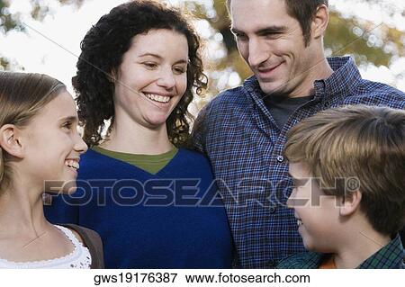 Stock Photo - Couple and their two children smiling. Fotosearch