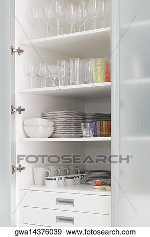 Stock Photo - Crockery in a kitchen shelf. Fotosearch
