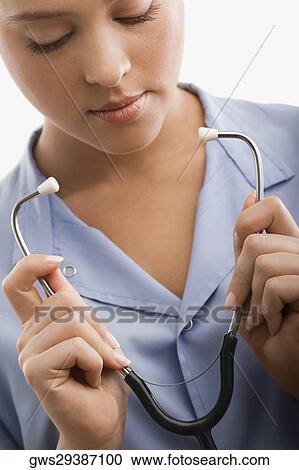 Stock Image - Female doctor holding a stethoscope. Fotosearch