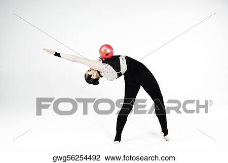 Stock Image - Female gymnast practicing with a ball. Fotosearch