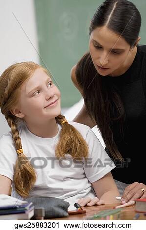 Female teacher teaching a schoolgirl in a classroom View Large Photo Image Stock Image - Female teacher teaching a schoolgirl in a classroom. Fotosearch