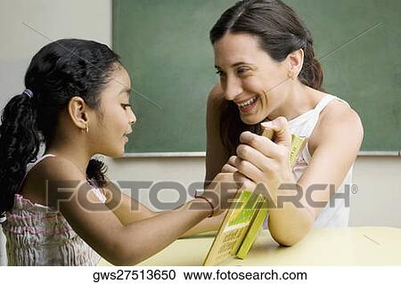 Female teacher teaching her student in a classroom View Large Photo Image Stock Image - Female teacher teaching her student in a classroom. Fotosearch