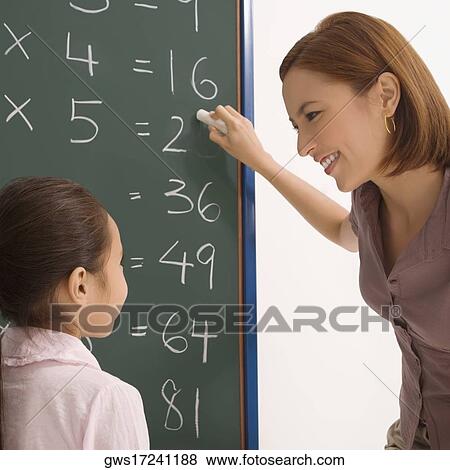 Stock Photo - Female teacher teaching her student in a classroom. Fotosearch
