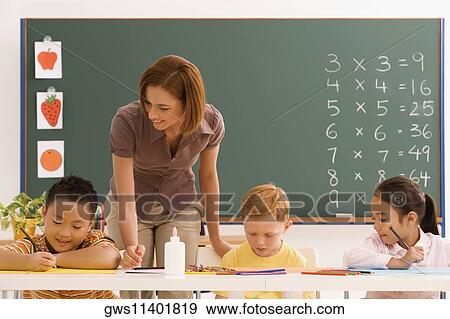 Female teacher teaching her students in a classroom View Large Photo Image Stock Photo - Female teacher teaching her students in a classroom. Fotosearch