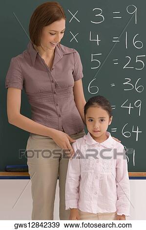 Female teacher with her student in a classroom View Large Photo Image Stock Photo - Female teacher with her student in a classroom. Fotosearch