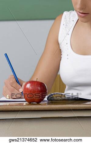 Female teacher writing on a textbook View Large Photo Image Stock Image - Female teacher writing on a textbook. Fotosearch
