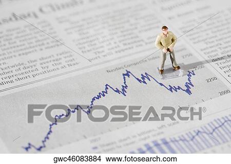 Figurine of a businessman standing on a financial newspaper View Large Photo Image Picture - Figurine of a businessman standing on a financial newspaper. Fotosearch