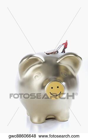 Figurine of a man putting a coin into a piggy bank View Large Photo Image Stock Photo - Figurine of a man putting a coin into a piggy bank. Fotosearch