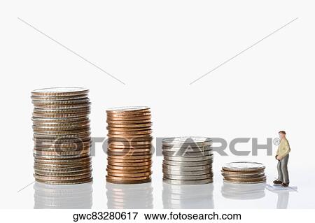 Stock Photo - Figurine of a man with stacks of coins. Fotosearch