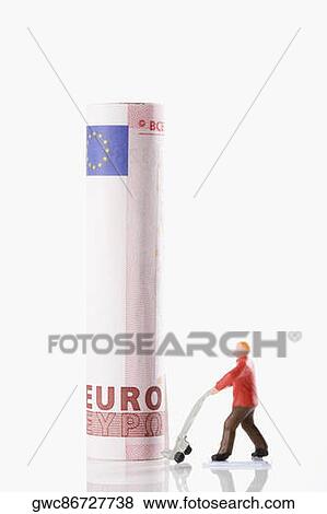 Figurine of a manual worker carrying European union euro note on a push cart View Large Photo Image Stock Photo - Figurine of a manual worker carrying European union euro note on a push cart. Fotosearch