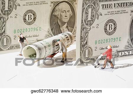 Stock Photo - Figurines of manual workers with US dollar bills. Fotosearch
